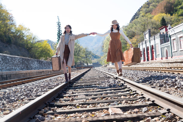 青年闺蜜手牵手走在铁轨上图片下载