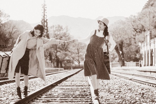 青年闺蜜手牵手走在铁轨上图片下载
