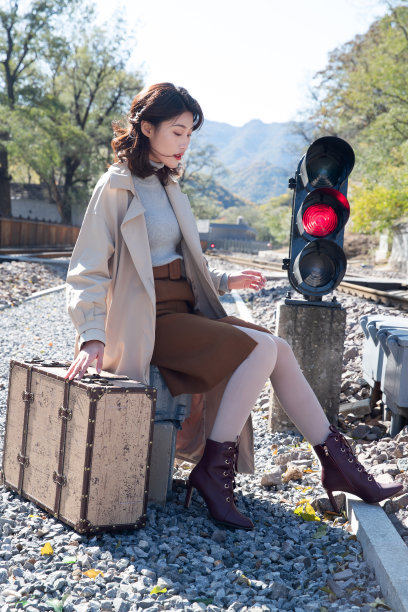青年女人坐在铁轨旁边图片下载