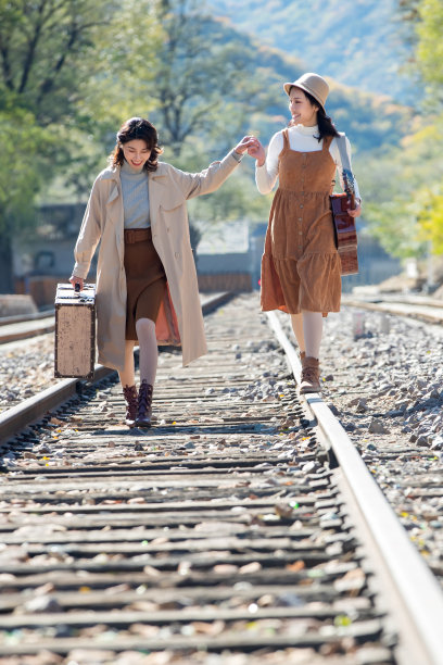 青年闺蜜手牵手走在铁轨上图片下载