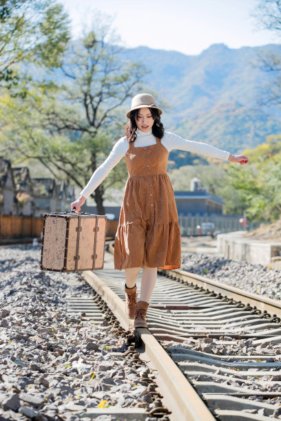 青年女人在铁轨上行走图片下载