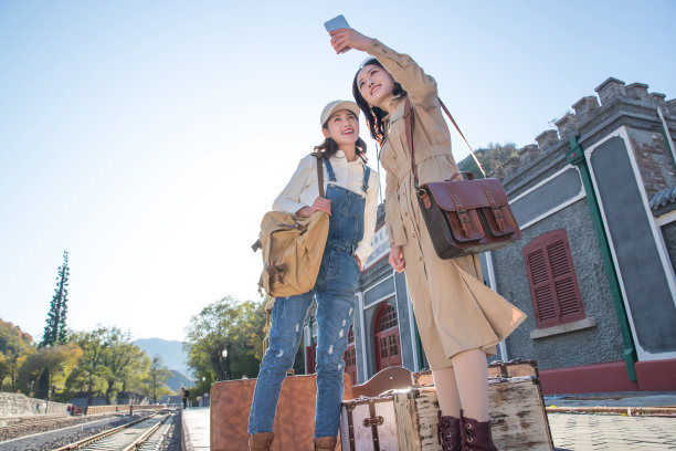 青年闺蜜在火车站站台看手机图片下载