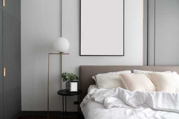 舒适的卧室角落，现代棕色织物床床头板和舒适的枕头设置，金色灯和人造植物玻璃花瓶在边桌上/室内设计装饰/复制空间图片下载