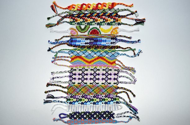设计师新颖独特的彩色多色友谊手链手工刺绣明亮的丝线和绳结孤立在白色的背景图片下载