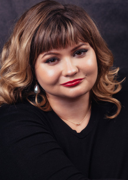 深色背景下穿着黑色毛衣的年轻俄罗斯女孩图片下载