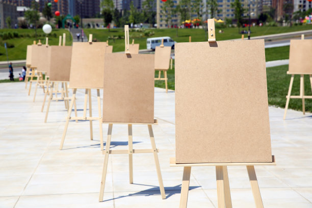 一对画架与空白画布。空白艺术板和现实的木制画架户外。城市街道上的画板画架空白展。木架与空白画布。图片下载