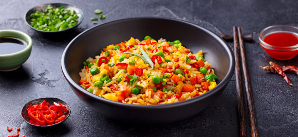 亚洲的鸡蛋和蔬菜炒饭。黑石的背景。关闭了。图片下载