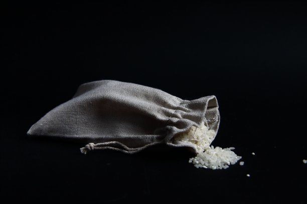 帆布袋大米孤立在黑色背景图片下载