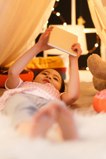 可爱的小女孩看着平板电脑图片下载