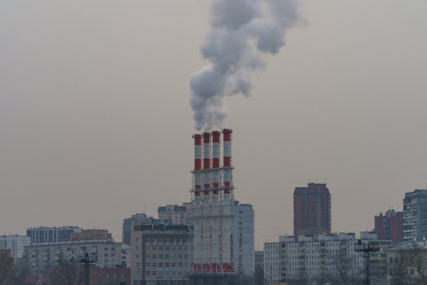 冬天天空背景上冒着烟的烟囱。图片下载
