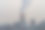 冬天天空背景上冒着烟的烟囱。图片下载
