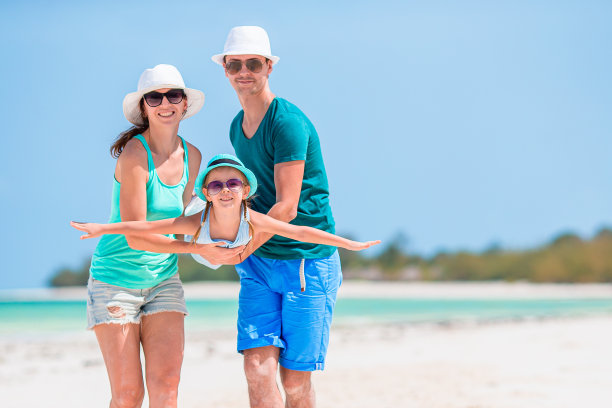 一个年轻的家庭在白色的海滩上度假图片下载