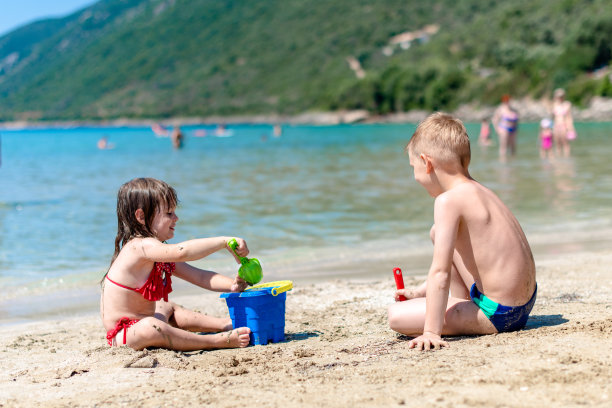 两个孩子在沙滩上玩沙子图片下载