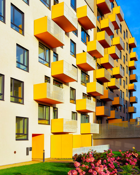 公寓住宅是现代住宅建筑的外观与鲜花和栅栏相反射图片下载