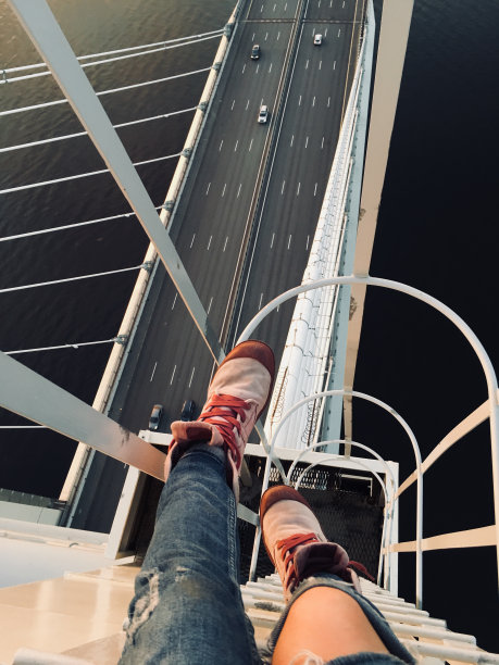 斜拉桥顶端的屋顶工人。手机摄影图片图片下载
