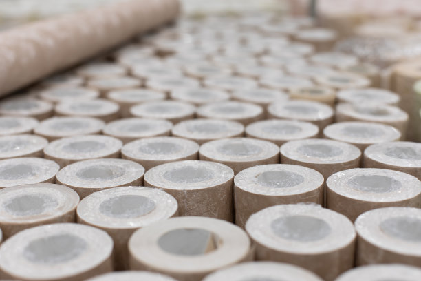 多卷墙纸，背景背景装饰设计。用于装饰墙壁和修理的米色墙纸被卷绕成塑料包装图片下载