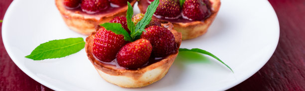 红色背景的白色盘子上的草莓馅饼横幅。图片下载