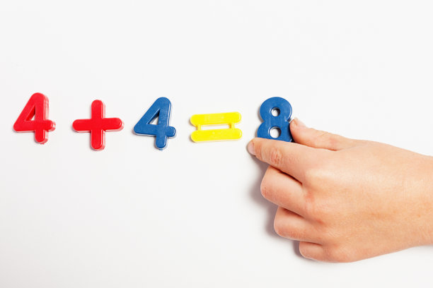 孩子的手用磁性数字做简单的数学运算图片下载
