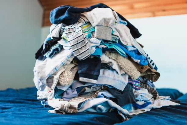 床上放了很多衣服。图片下载