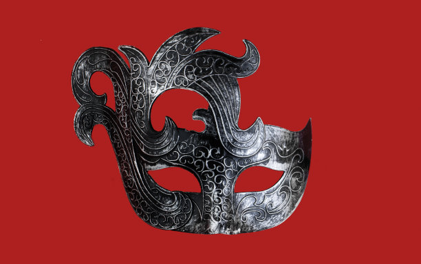 银色的黑色狂欢节面具孤立在红色的背景。狂欢节服装。素材图片