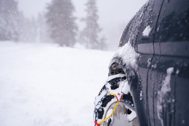 观点。冬天的轮胎在下雪的路上行驶。给轮胎上链子。冬天的道路安全。图片下载