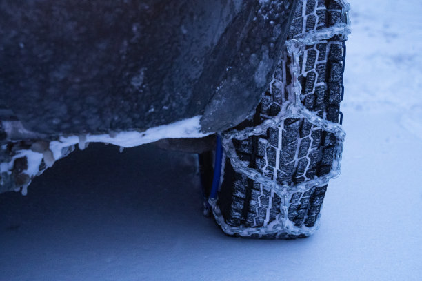 观点。冬天的轮胎在下雪的路上行驶。给轮胎上链子。冬天的道路安全。图片下载