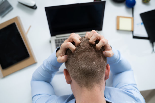 在办公桌前使用笔记本电脑的有压力的商人图片下载