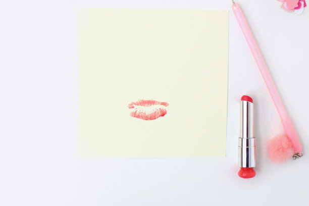 平铺:黄色的纸，带绒球的粉色钢笔，口红，心形彩纸，唇印。在信封里制作情人节明信片。做你自己。系列图片图片下载