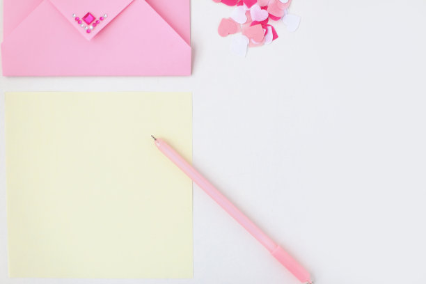 平铺:黄色的纸，粉红色的信封，上面有人造钻石，钢笔，绒球，心形碎纸。在信封里制作情人节明信片。做你自己。系列图片图片下载