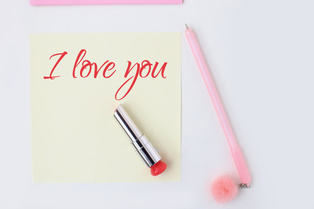 平铺:黄色的纸，粉色的笔，绒球，口红，心形彩纸，唇印，我爱你的文字。在信封里制作情人节明信片。做你自己。系列图片图片下载