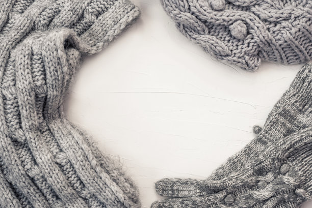 温暖的女性灰色针织手套，围巾和帽子在白色纹理的背景。平躺，俯视图简约时尚概念。图片下载