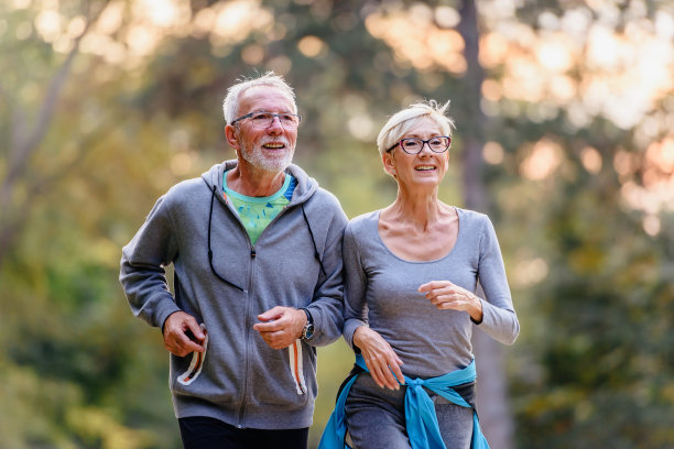 一对活泼愉快的老年夫妇早上在公园慢跑图片下载