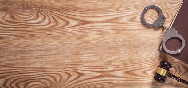 木质背景上的手铐、书籍和法槌图片下载