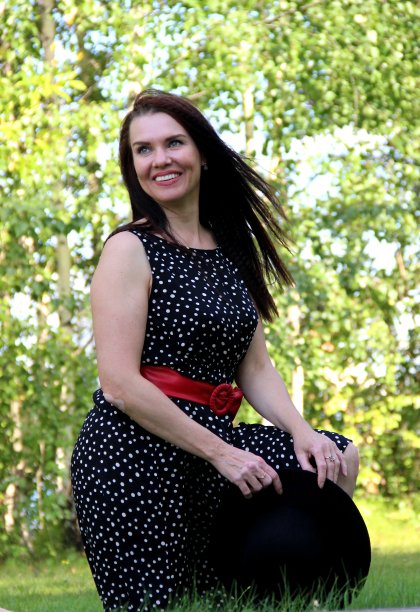 微笑的黑发，长长的黑发，黑色的夏装，红色的腰带和黑色的帽子在她的手中图片下载