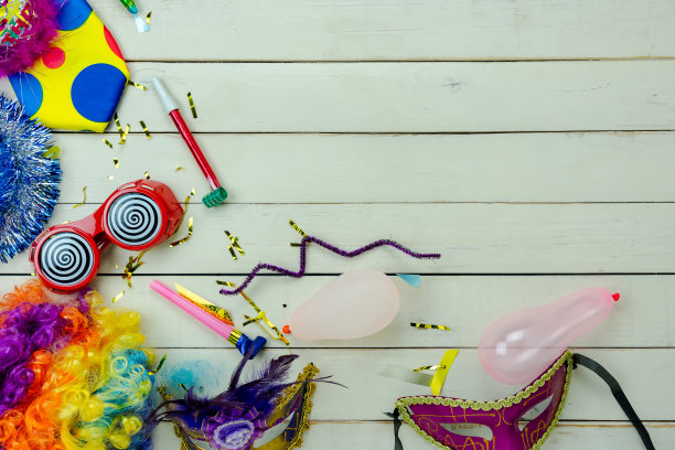 桌面鸟瞰图美丽多彩的狂欢节节日背景。平面铺设配件对象的几个面具和装饰五彩纸屑在现代灰色水泥在家庭办公室办公桌工作室。副本的空间。图片下载