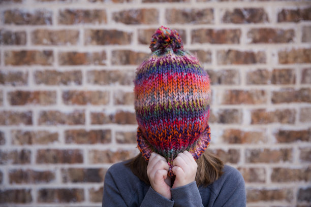 年轻女孩戴着冬帽遮住脸图片下载