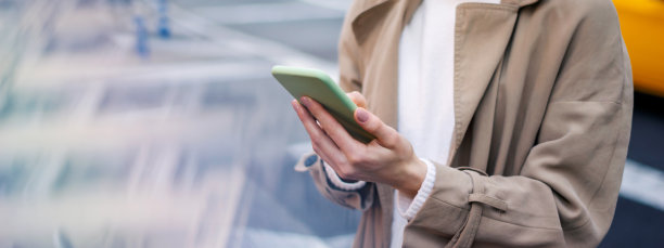 女性手与智能手机的特写照片。夜晚的街道背景图片下载