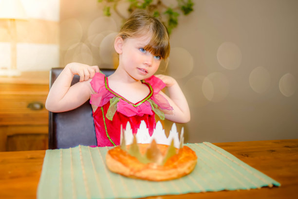 可爱的小女孩站在主显节蛋糕前图片下载