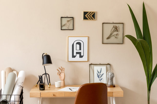 时尚的斯堪的纳维亚室内家庭办公空间有许多模拟的相框，木制书桌，棕色椅子，植物，办公室和个人配件。现代中性家庭登台。模板。图片下载