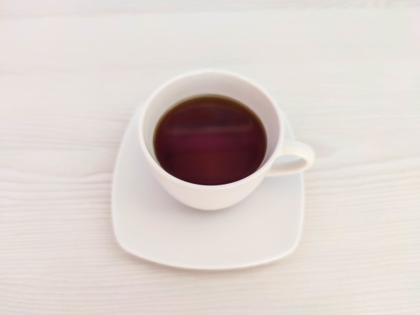 在有复印空间的木桌上放上一杯白色的茶或咖啡和一个茶托。一张为café或餐厅菜单或包装背景的照片。图片下载