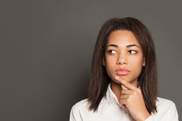 在灰色背景下思考的非裔美国妇女图片下载