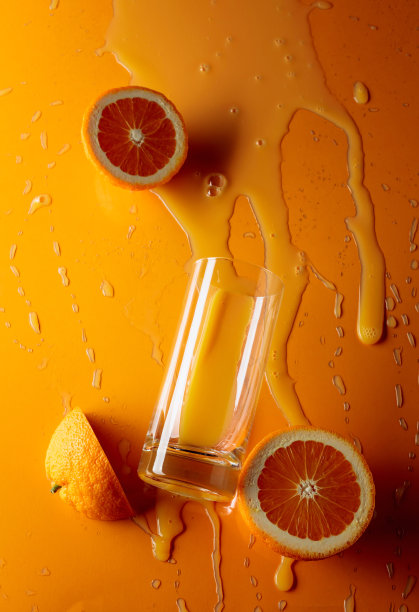 橙汁配以橘色背景的水果。图片下载