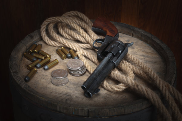 老式西部左轮手枪、弹药和银元图片下载