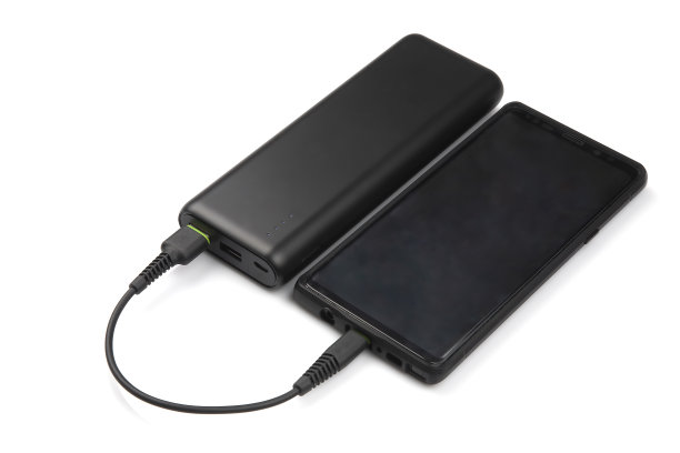 Powerbank在白色背景下为智能手机电池充电。数字技术与设备图片下载