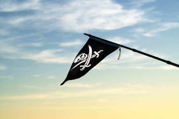 海盗旗迎风飘扬，映衬着傍晚五彩缤纷的天空图片下载