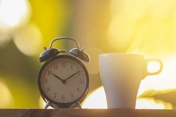 黑色的闹钟，一杯咖啡，还有迷人的晨光图片下载