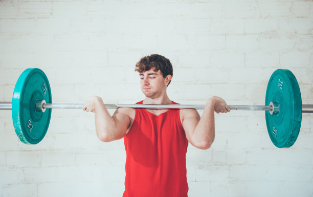 年轻人用绿色的重量训练图片下载