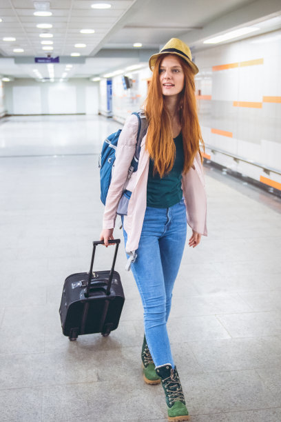 一位年轻女子带着一个手提箱去旅行图片下载