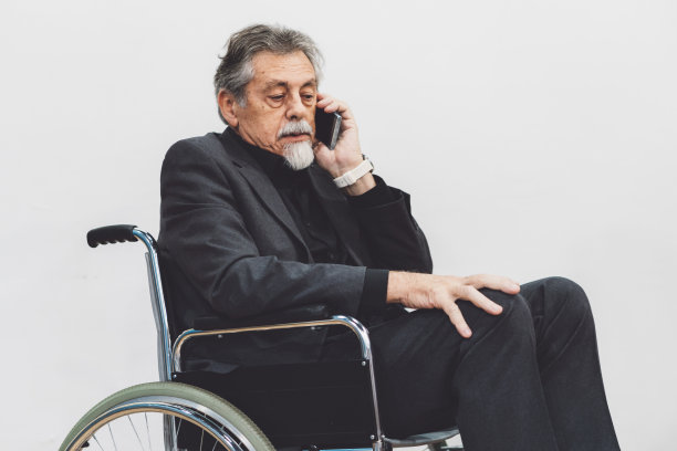 一个坐在轮椅上打电话的残疾人图片下载