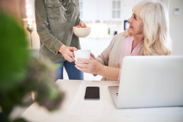 快乐成熟的女士看着家里的女志愿者图片下载